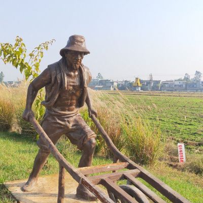 頭戴草帽，身穿坎肩，推獨輪車的老漢銅雕